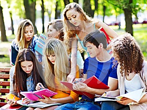 Group student with notebook on bench outdoor.