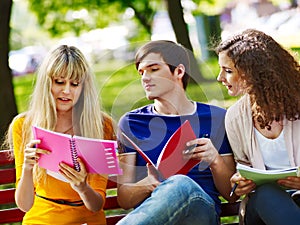 Group student with notebook on bench outdoor.