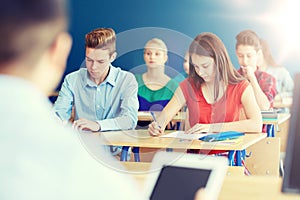 Group of students with books writing school test