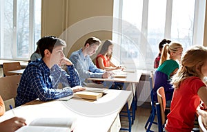 Group of students with books writing school test