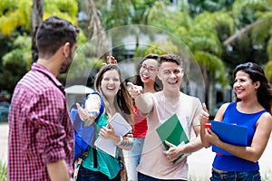 Group of students congratulating to a male student