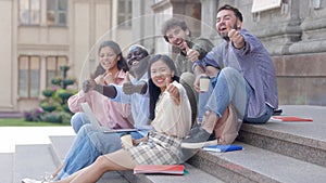 group of students giving a thumbs up .