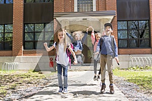 A Group of students jump outside at school standing together