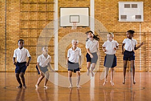 Group of students jumping in school gym