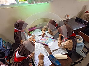 A group of students are learning to recognize and translate the Javanese script in class.