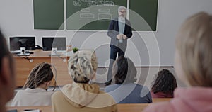 Group of students listening to English teacher learning language grammar in university classroom