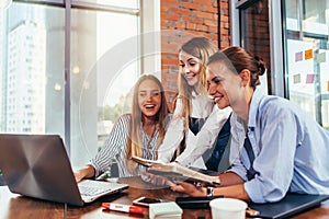 Group of students looking at laptop taking a break after studying in college study room