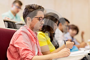 Group of students with notebooks in lecture hall