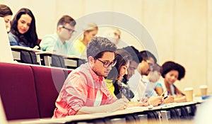 Group of students with notebooks in lecture hall photo