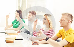 Group of students raising hands. Teenagers study in a classroom