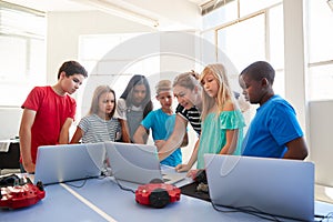 Group Of Students In After School Computer Coding Class Learning To Program Robot Vehicle