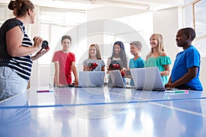 Group Of Students In After School Computer Coding Class Learning To Program Robot Vehicle