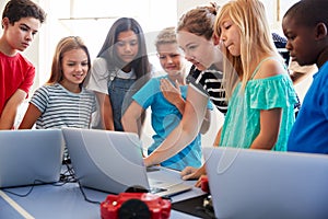 Group Of Students In After School Computer Coding Class Learning To Program Robot Vehicle