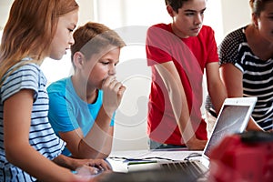 Group Of Students In After School Computer Coding Class Learning To Program Robot Vehicle