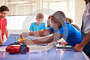 Group Of Students In After School Computer Coding Class Learning To Program Robot Vehicle