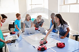Group Of Students In After School Computer Coding Class Learning To Program Robot Vehicle