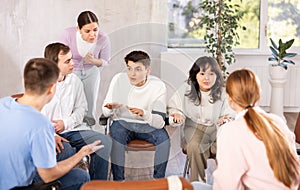 Group of students sitting in circle studying together in study hall of university