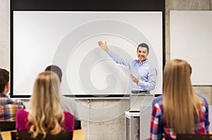 Group of students and smiling teacher with notepad