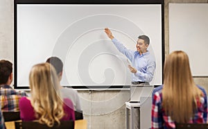 Group of students and smiling teacher with notepad