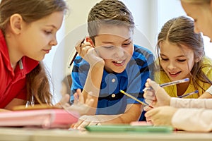 Group of students talking and writing at school