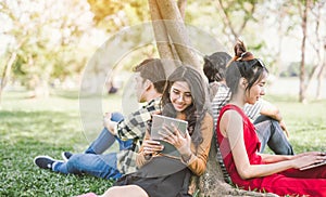 Group of students or teenagers with laptop and tablet computers hanging out