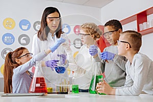 Group of students and their teacher conducting chemical experiment