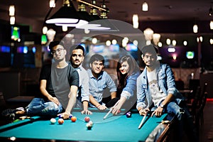 Group of stylish asian friends wear on jeans playing pool billiard on bar