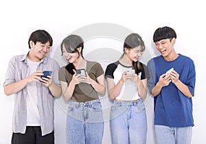 Group of stylish students using mobile phone stand before white background