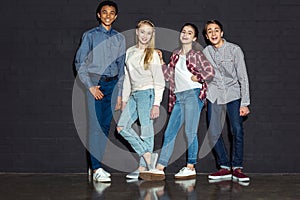 group of stylish teens standing together and looking at camera photo