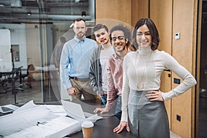 group of successful architects standing in row and looking at camera