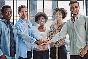 a group of successful business diverse people in the office stands embracing