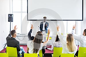 Group of successful business people at the lecture asking questions during team seminar