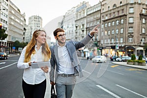 Group of successful business people working, walking in a city street.