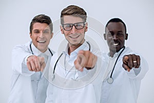 Group of successful doctors pointing to you.