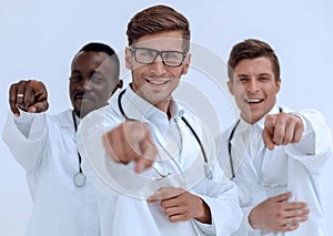 Group of successful doctors pointing to you.