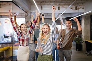 Group of successful happy business people in office celebrating profits