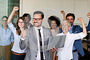 Group of successful multiethnic business people celebrating a good job in the office