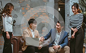 Group of successful partner Asian businesspeople wearing formal clothes, making handshaking for dealing agreement or contract whil