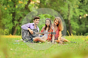 Group of successful students with a guitar resting