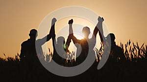 A group of successful young people hold hands, together they raise their upper hand. Successful team and team building