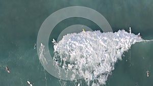 Group of surfers catching a wave in Pacific Ocean near Waikiki Beach on Oahu