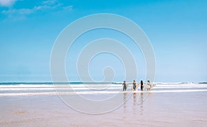 Group surfers girls with boards stay on ocean surf line and ready to go into water. Never ending summer surfing concept image