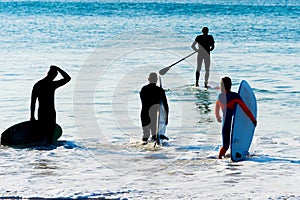 Group surfers going  surf SIlhouette