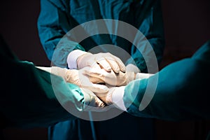 Group Surgeon doctor joining hands before Patient surgery in hospital operating room.