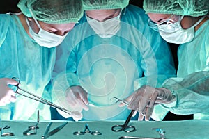 Group of surgeons in masks performing operation. Scene of operation room colored in green. Medicine, surgery and