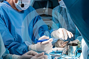 A group of surgeons performing minimally invasive surgery on the patient's anus using surgical instruments