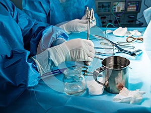 A group of surgeons performing minimally invasive surgery on the patient`s anus using surgical instruments.