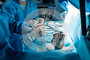 A group of surgeons performing minimally invasive surgery on the patient's anus using surgical instruments.