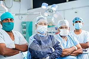 group of surgeons standing confidently by looking at camera at operation theater - concpet of healthcare, teamwork