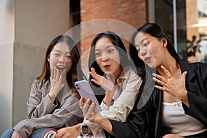 Group of surprised young Asian female friends are surprised with an online discount on shopping app